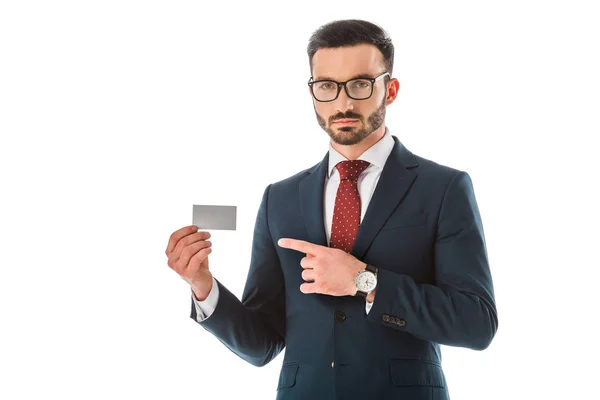 Seriöser Geschäftsmann zeigt mit dem Finger auf leere Visitenkarte und blickt isoliert auf weiße Kamera — Stockfoto