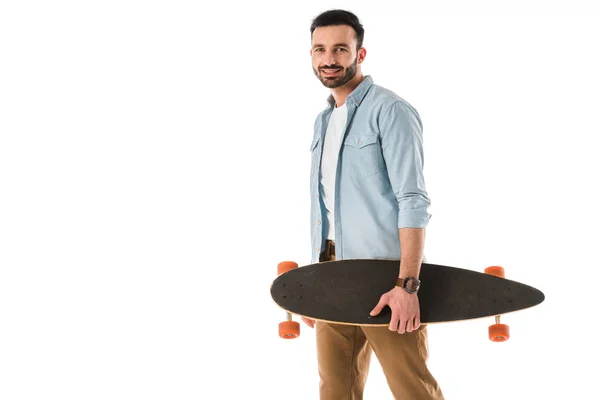 Schöner lächelnder Mann mit Longboard und Blick in die Kamera isoliert auf weiß — Stockfoto