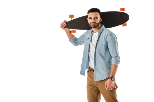 Bonito sorrindo homem segurando longboard no ombro e olhando para a câmera isolada no branco — Fotografia de Stock