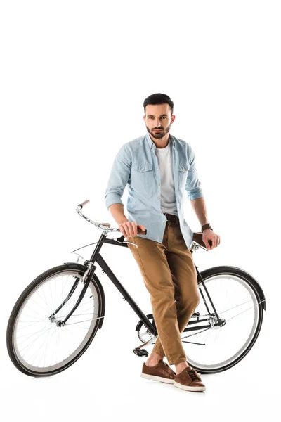 Seroso barbudo homem com bicicleta olhando para câmera isolada no branco — Fotografia de Stock