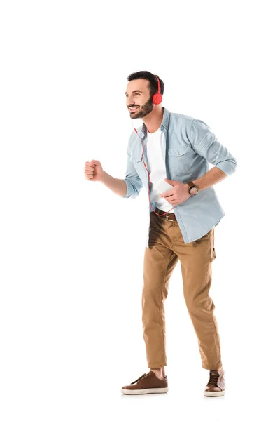 Happy man in headphones listening music and dancing isolated on white — Stock Photo