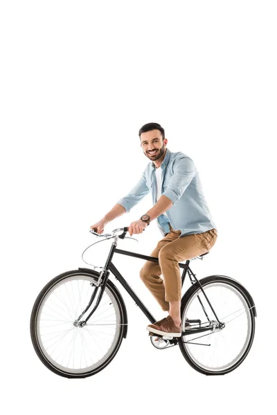 Hombre barbudo alegre montar en bicicleta y sonriendo a la cámara aislado en blanco - foto de stock