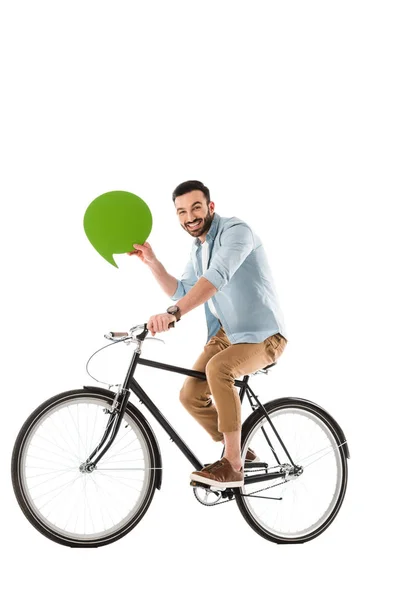 Hombre barbudo alegre montar en bicicleta mientras sostiene la burbuja de pensamiento aislado en blanco - foto de stock