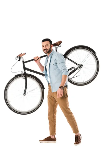 Красивый улыбающийся мужчина, держащий велосипед и смотрящий на камеру, изолированную на белом — стоковое фото