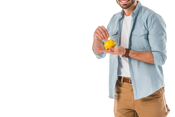 Partial view of smiling man putting coin into moneybox isolated on white — Stock Photo