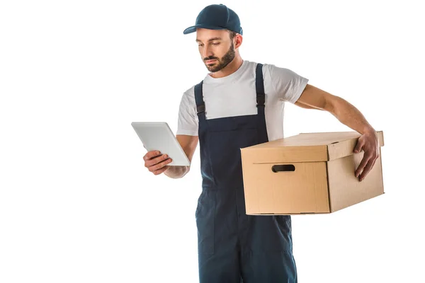 Aufmerksamer Zusteller mit digitalem Tablet, während er Pappschachtel isoliert auf weiß hält — Stockfoto