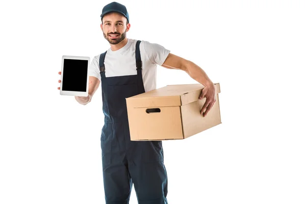Guapo repartidor con caja de cartón sosteniendo tableta digital con pantalla en blanco y mirando a la cámara aislada en blanco - foto de stock