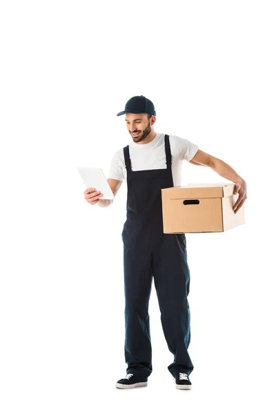 Cheerful courier looking at paper with order while holding cardboard box isolated on white — Stock Photo