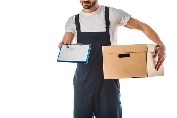 Partial view of delivery man with cardboard box holding clipboard with blank paper isolated on white — Stock Photo