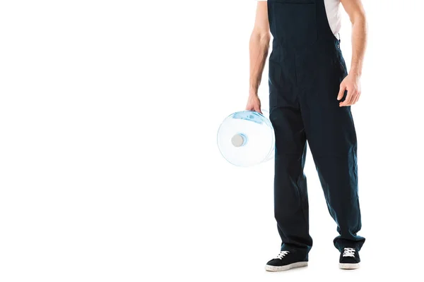 Partial view of delivery man in overalls holding bottle of water isolated on white — Stock Photo