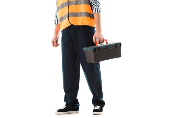 Cropped view of construction worker in safety vest holding toolbox isolated on white — Stock Photo