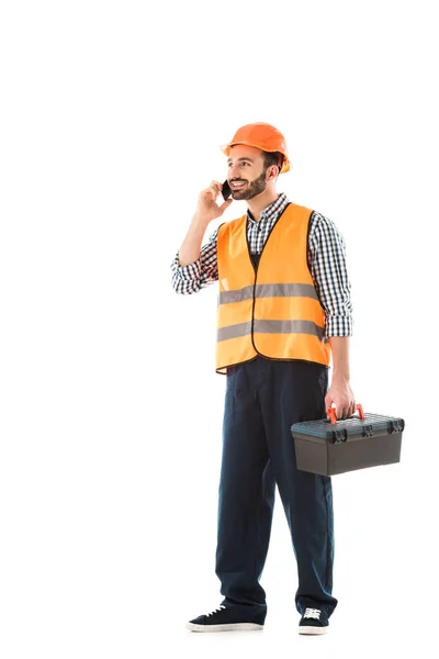 Travailleur de la construction souriant parler sur smartphone tout en tenant la boîte à outils et en regardant loin isolé sur blanc — Photo de stock