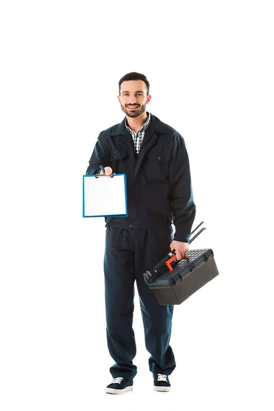 Smiling plumber holding clipboard with blank paper, toolbox and adjustable wrench isolated on white — Stock Photo