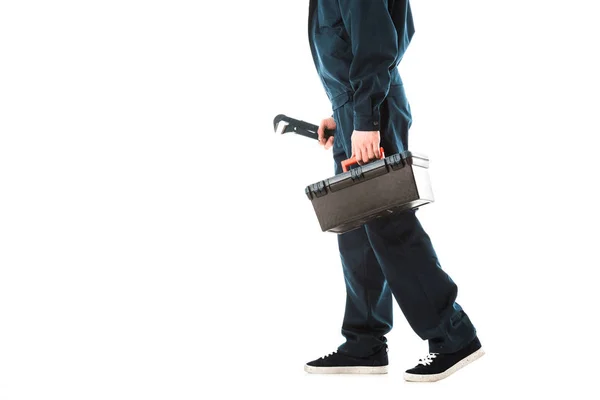 Partial view of repairman in overalls holding toolbox and adjustable wrench isolated on white — Stock Photo