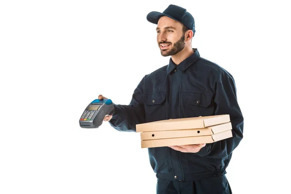 Mensajero sonriente en overoles con terminal de pago y cajas de pizza aisladas en blanco - foto de stock