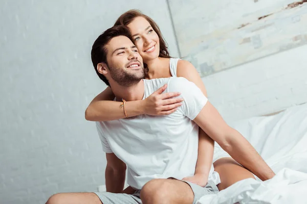Happy woman hugging handsome boyfriend in bedroom — Stock Photo