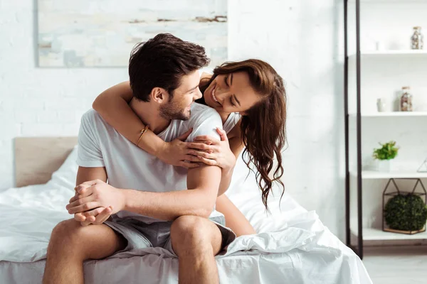 Alegre joven mujer abrazando guapo novio en dormitorio — Stock Photo