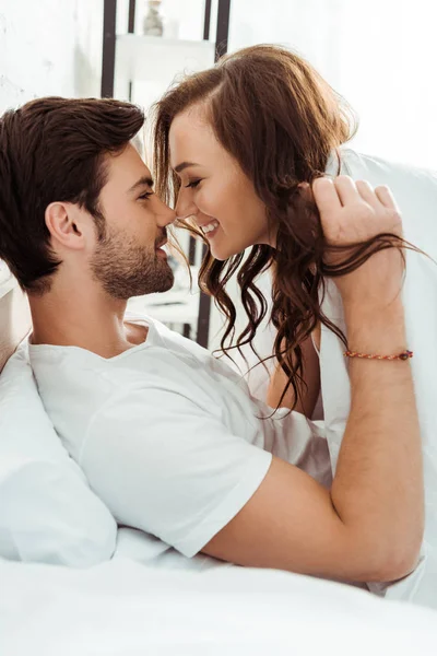 Guapo hombre mirando feliz joven mujer en el dormitorio - foto de stock