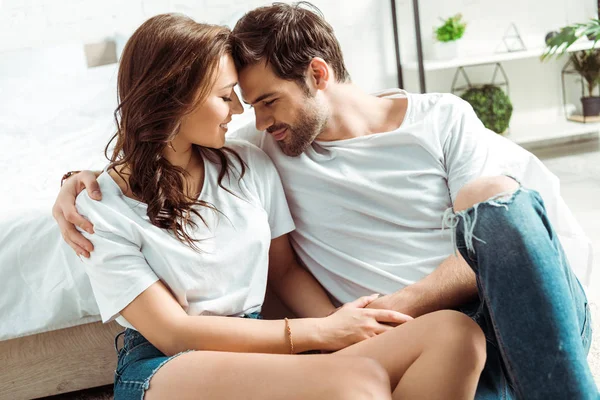 Fröhlicher Mann und glückliches Mädchen sitzen mit geschlossenen Augen im Schlafzimmer — Stockfoto