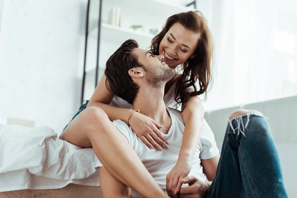 Bajo ángulo vista de hombre guapo mirando alegre chica en casa - foto de stock