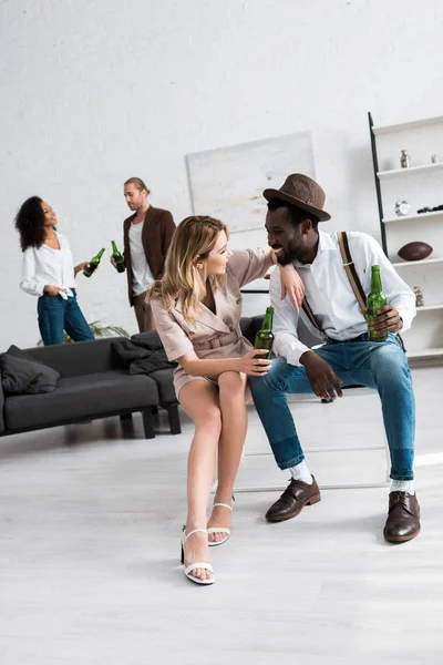 Foco seletivo de mulher feliz sorrindo perto de homem americano africano com cerveja — Fotografia de Stock