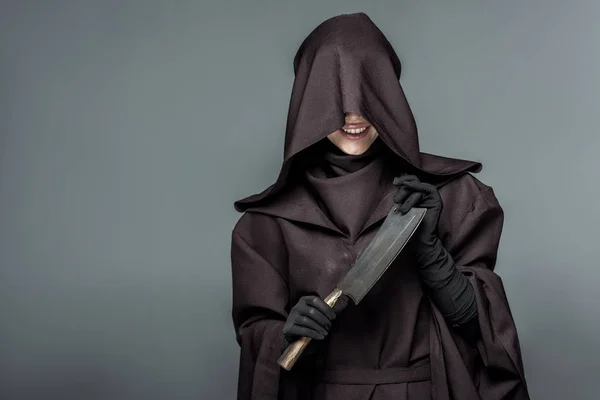 Mulher sorridente no traje da morte segurando cutelo isolado em cinza — Fotografia de Stock