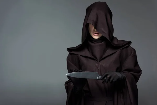 Женщина в костюме смерти держит нож изолированный на сером — стоковое фото