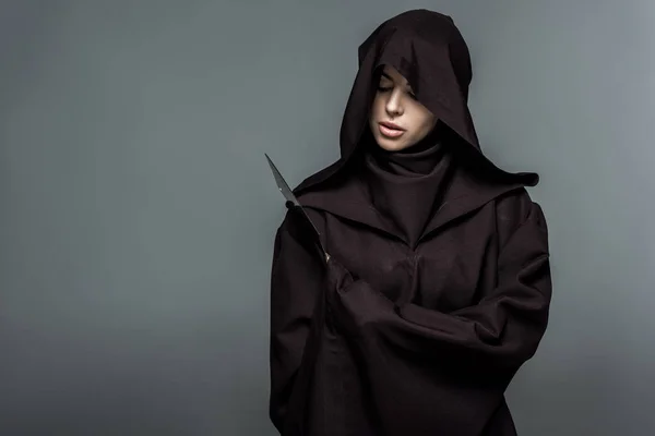 Woman in death costume holding knife isolated on grey — Stock Photo