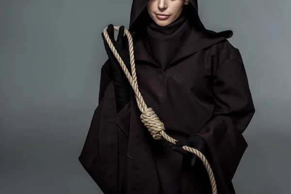 Cropped view of woman in death costume holding hanging noose isolated on grey — Stock Photo