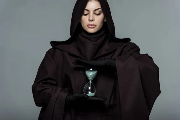 Жінка в костюмі смерті тримає пісковик ізольовано на сірому — стокове фото