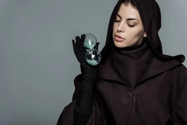 Femme en costume de mort tenant verre de sable isolé sur gris — Photo de stock