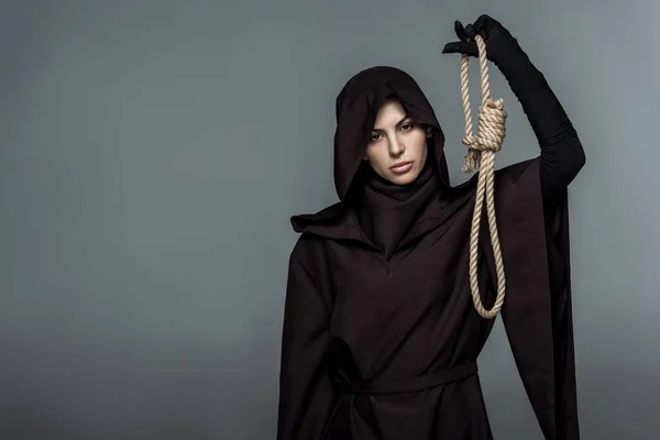 Woman in death costume holding hanging noose isolated on grey — Stock Photo