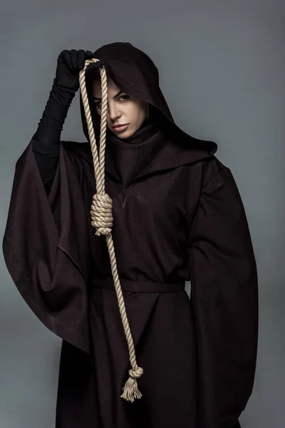 Mujer en traje de muerte sosteniendo soga colgante aislado en gris - foto de stock