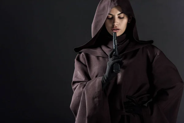 Woman in death costume holding gun isolated on black — Stock Photo