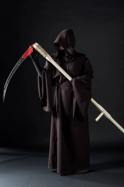 Повний вигляд жінки в костюмі смерті, що тримає скіфі на чорному — стокове фото