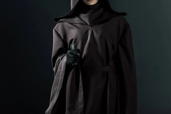 Обрізаний вид жінки в костюмі смерті, прицільний пістолет на камеру на чорному — стокове фото