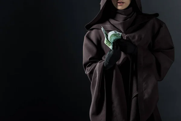 Cropped view of woman in death costume holding euro banknotes isolated on black — Stock Photo