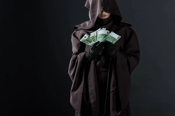 Vista ritagliata di donna in costume da morte in possesso di banconote in euro isolate su nero — Foto stock