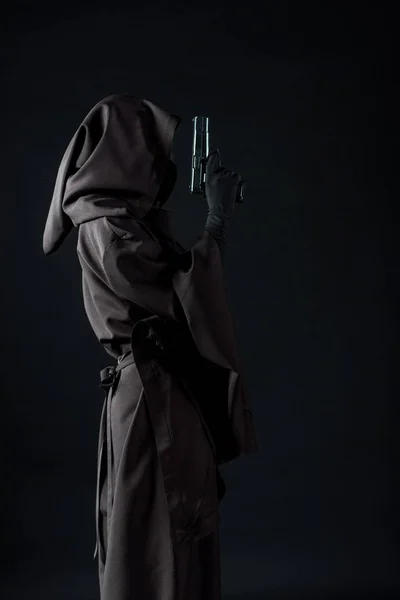 Side view of woman in death costume holding gun isolated on black — Stock Photo