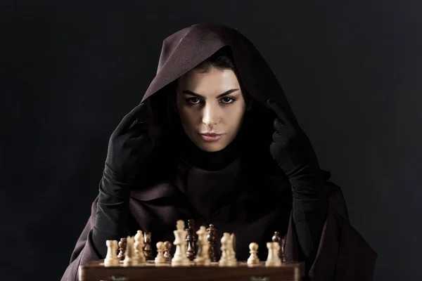 Front view of woman in death costume with chess isolated on black — Stock Photo