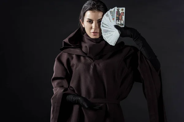 KYIV, UCRAINA - 18 APRILE 2019: vista frontale della donna in costume da morte con in mano tarocchi isolati su nero — Foto stock