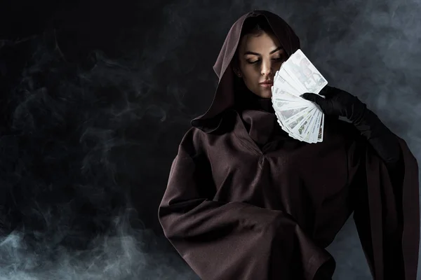 KYIV, UKRAINE - APRIL 18, 2019: woman in death costume holding tarot cards on black — Stock Photo