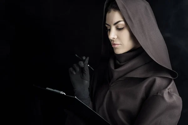 Frau im Todeskostüm hält Klemmbrett auf schwarz — Stockfoto