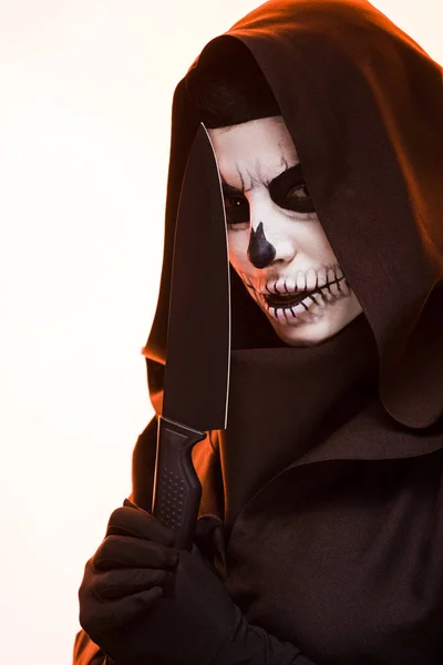 Mujer con cráneo maquillaje celebración cuchillo aislado en blanco - foto de stock