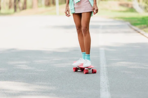 Visão parcial da menina africana americana skate na estrada — Fotografia de Stock
