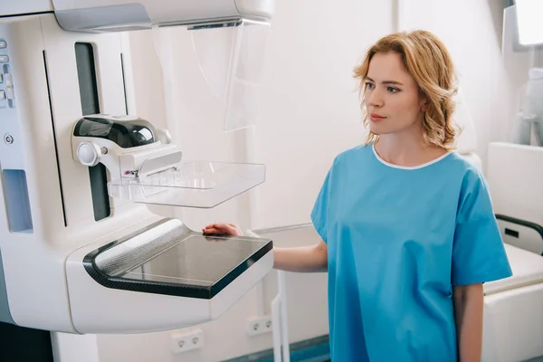 Belle femme adulte debout près de la machine à rayons X à l'hôpital — Photo de stock