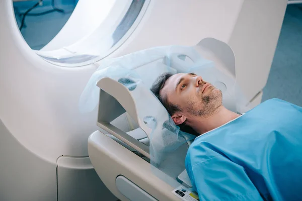 Adulto bello uomo sdraiato sul letto ct scansione durante il test di tomografia — Foto stock