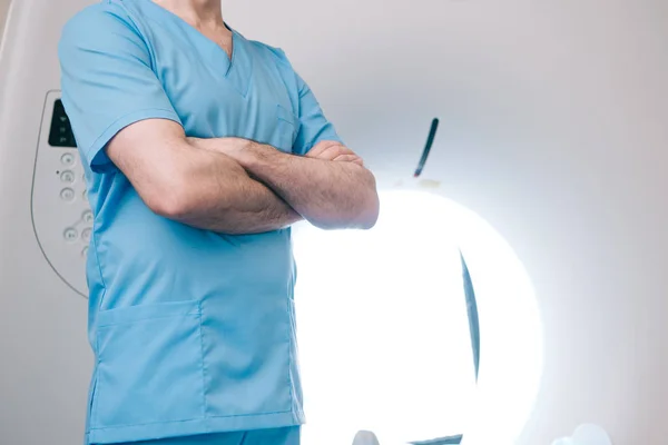 Vue partielle du médecin debout avec bras croisés près du scanner ct — Photo de stock