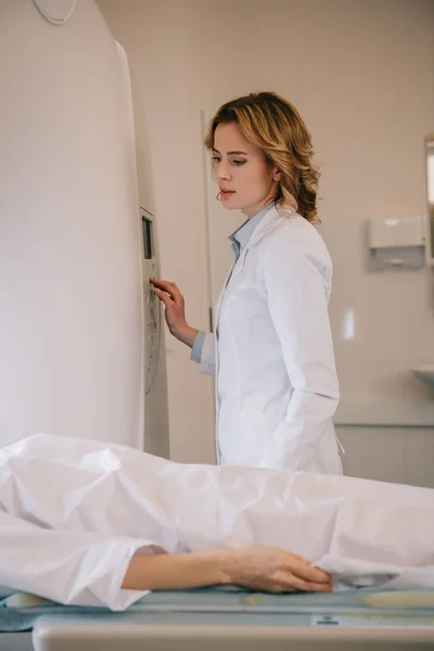 Beaux radiologues opérant ct scanner pendant les diagnostics de tomographie des patients — Stock Photo