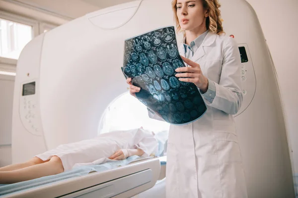 Radiologiste attentif examinant le diagnostic de tomographie pendant le diagnostic des patients — Photo de stock